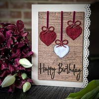 Handcrafted 5x7 birthday card with natural wool filled hearts on rustic wood background
