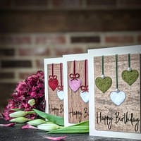 Handcrafted 5x7 birthday card with natural wool filled hearts on rustic wood background